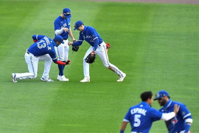 Toronto Blue Jays left fielder Lourdes Gurriel Jr., top left, center fielder Randal Grichuk, top center, and right fielder Cavan Biggio celebrate a win over the New York Mets in a baseball game in Buffalo, N.Y., Sunday, Sept. 13, 2020. (AP Photo/Adrian Kraus)