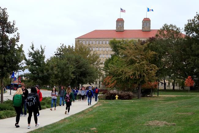 FILE - In this Oct. 24, 2019, file photo students walks in front of Fraser Hall on the University of Kansas campus in Lawrence, Kan. Student loan forgiveness might be on the way after all, according to experts who see the tax break included in the $1.9 trillion stimulus package as a bellwether. The tax break would ensure any debt forgiven from Dec. 31, 2020, to Jan. 1, 2026, won’t be counted as income — effectively nixing the argument that cancellation would prompt a tax burden on borrowers. (AP Photo/Orlin Wagner, File)