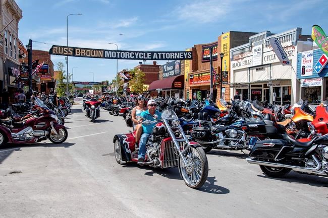 FILE - In this Aug. 15, 2020 file photo, bikers ride down Main Street during the 80th annual Sturgis Motorcycle Rally in Sturgis, S.D. This summer’s huge motorcycle rally in South Dakota led to dozens of coronavirus cases in neighboring Minnesota. That’s the finding of a report Friday, Nov. 20, from the Centers for Disease Control and Prevention. (Amy Harris/Invision/AP)