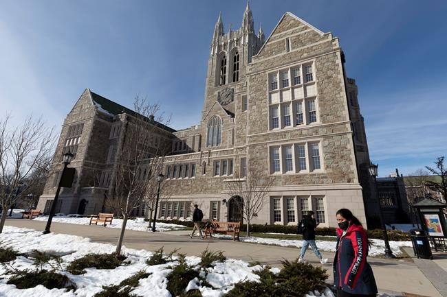 FILE - In this Feb. 17, 2021 file photo, students walk on the Boston College campus in Boston. President Joe Biden campaigned on multiple tuition-free college proposals. But experts are divided on whether now is the time students could see a broad free college program. (AP Photo/Michael Dwyer, File)