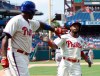 FILE - In this Aug. 20, 2014, file photo, Philadelphia Phillies' Jimmy Rollins, right, celebrates his run with Ryan Howard on a single by Chase Utley during the fifth inning of the team's baseball game against the Seattle Mariners in Philadelphia. When Rollins made his first All-Star team as a rookie with the Phillies 20 years ago, the percentage of Black players in the majors was 13. It’s down to 7.6% this year. Rollins pointed to Ken Griffey Jr. and Barry Bonds as popular players who were marketed well when he was growing up. “But when you start going outside of that select few, the sport itself isn’t marketing anyone else in a major way where kids from the inner cities are attracted to it,