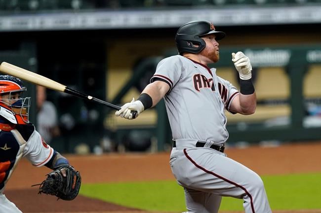 FILE - In this Sept. 18, 2020, file photo, Arizona Diamondbacks' Kole Calhoun follows through on a home run as Houston Astros catcher Martin Maldonado watches during a baseball game in Houston. Calhoun will have surgery Wednesday on his right knee because of a medial meniscus tear. Arizona manager Torey Lovullo said on Tuesday that he wasn’t sure if the injury means Calhoun will miss opening day on April 1. (AP Photo/David J. Phillip, File)