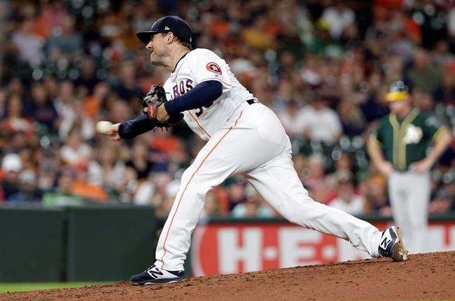 FILE - In this Sept. 12, 2019, file photo, Houston Astros relief pitcher Joe Smith throws to an Oakland Athletics batter during a baseball game in Houston. Manager Dusty Baker doesn’t expect Smith to play for the Astros this season. Smith has not reported to camp because of what general manager James Click called concerns for the safety of his family. Smith was placed on the restricted list Tuesday night, July 15, but he has not said publicly if he is opting out of the season, which starts for the Astros on July 24. (AP Photo/Michael Wyke, File)