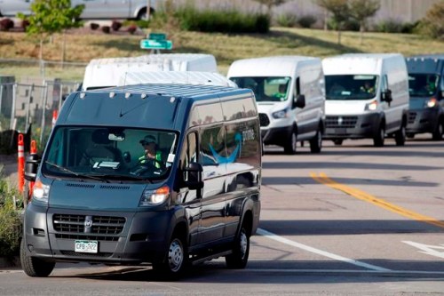 FILE - In this July 30, 2019, file photo, vans queue up to leave an Amazon delivery center in suburban Englewood, Colo. Amazon said Tuesday, June 23, 2020, that its carbon footprint rose 15% last year, even as it launched initiatives to reduce its harm on the environment. (AP Photo/David Zalubowski, File)