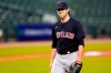 FILE - In this Sept. 17, 2020, file photo, Cleveland Indians pitcher Shane Bieber smiles as he walks to the dugout in the fourth inning of a baseball game against the Detroit Tigers in Detroit. Bieber has reported to training camp with the Cleveland Indians after recovering from COVID-19. The right-hander took part in drills on Saturday, Feb. 20, 2021, a day before the Indians hold their first full-squad workout in Goodyear, Ariz. (AP Photo/Paul Sancya, File)