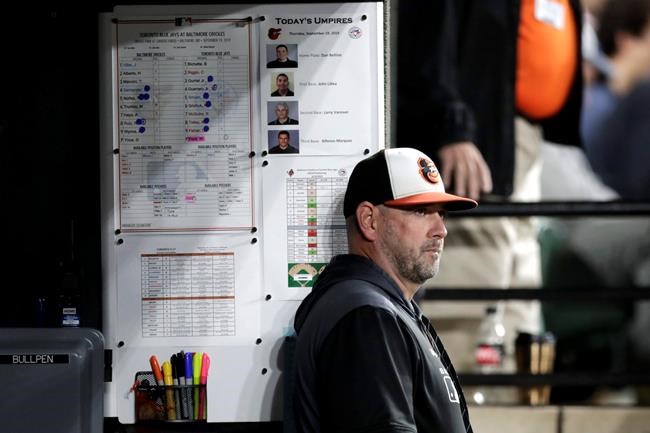 FILE - In this Sept. 19, 2019, file photo, Baltimore Orioles manager Brandon Hyde watches from the dugout during the seventh inning of a baseball game against the Toronto Blue Jays in Baltimore. Hyde enters his second spring training as manager of the Baltimore Orioles with the same goal as last year: to oversee the rebuild of a last-place team that lost more than 100 games. (AP Photo/Julio Cortez, File)