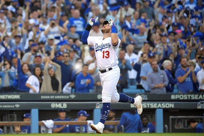 FILE- In this Oct. 9, 2019, file photo, Los Angeles Dodgers' Max Muncy celebrates his two-run home run against the Washington Nationals during the first inning in Game 5 of a baseball National League Division Series in Los Angeles. Muncy and the Dodgers agreed to a $26 million, three-year contract Thursday, Feb. 6, 2020, and avoided salary arbitration. (AP Photo/Mark J. Terrill, File)