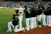 FILE - In this Sept. 23, 2017, file photo, Oakland Athletics catcher Bruce Maxwell kneels during the national anthem before the start of a baseball game against the Texas Rangers in Oakland, Calif. The New York Mets have agreed to a minor league contract with Maxwell, the first major league player to kneel during the national anthem to protest racial injustice in 2017, according to a person familiar with the deal. (AP Photo/Eric Risberg, File)