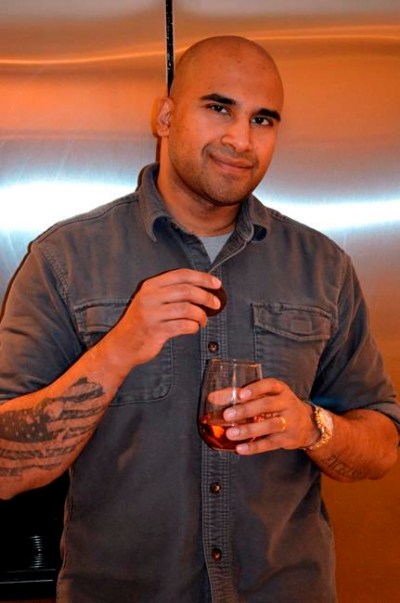 This Jan. 30, 2021, photo shows Rex Chatterjee with an Oreo cookie in one hand and a glass of rose in the other at his home in Amagansett, N.Y. Whether it’s odd food pairings or the embrace of long-despised kimchi, beets or broccoli, the pandemic has had a strange impact on food cravings that goes beyond the joy of comfort eating. (Carlyn Coy via AP).