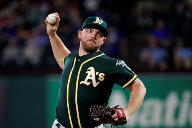 FILE - In this Sept. 14, 2019, file photo, Oakland Athletics relief pitcher Liam Hendriks works against the Texas Rangers during a baseball game in Arlington, Texas. Hendriks had to help somehow when fires ravaged his homeland in Australia this winter. He briefly got home to Perth but mostly campaigned on social media from a world away to generate awareness and support for Red Cross Australia. (AP Photo/Tony Gutierrez, File)