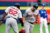 Boston Red Sox third base coach Carlos Febles (52) celebrates with Hunter Renfroe, right, after Renfroe hit a grand slam during the first inning of a baseball game against the Toronto Blue Jays on Monday, July 19, 2021, in Buffalo, N.Y. (AP Photo/Joshua Bessex)