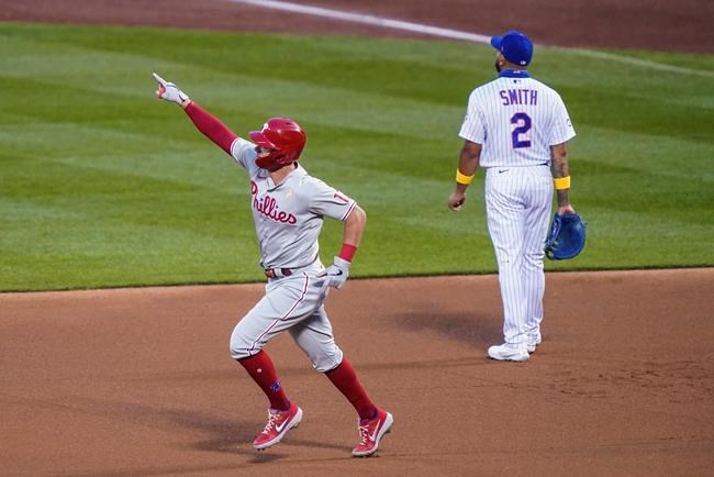 Philadelphia Phillies' Rhys Hoskins celebrates as he runs the bases past New York Mets first baseman Dominic Smith (2) after hitting a solo home run off starting pitcher Seth Lugo during the first inning of a baseball game Saturday, Sept. 5, 2020, in New York. (AP Photo/John Minchillo)