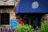 A door attendant wears a protective mask outside the clubhouse on the second day of practices before the U.S. Open Championship golf tournament at Winged Foot Golf Club, Tuesday, Sept. 15, 2020, in Mamaroneck, N.Y. (AP Photo/John Minchillo)