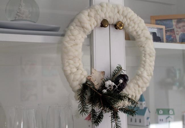 This Dec. 16, 2019 photo taken in Hopkinton, N.H., shows one of three ways to make holiday wreaths with yarn. Weaving long pieces of fuzzy, roving-like yarn between the hoops of a wire form results in a rustic wreath easily adorned with greenery and birch bark. (AP Photo/Holly Ramer)