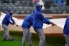 New York Mets employees put a tarp over the field during a delay in the first inning of a baseball game against the Miami Marlins at Citi Field, Sunday, April 11, 2021, in New York. The game was delayed at the top of the first inning due to rain. (AP Photo/Seth Wenig)