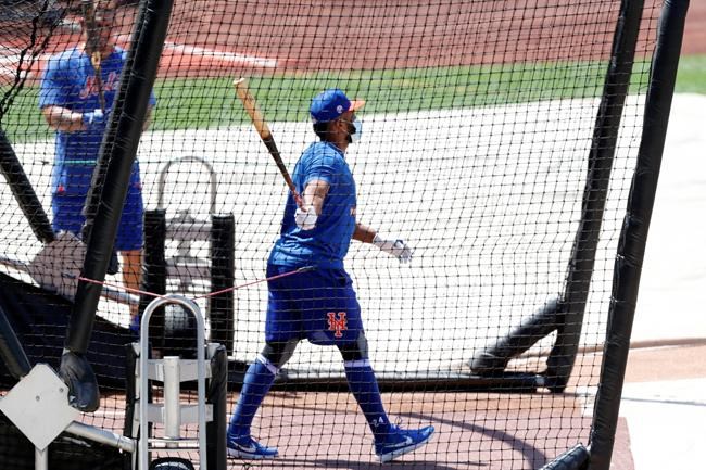 New York Mets' Robinson Cano, right, exits the batting cage during baseball practice at Citi Field, Thursday, July 16, 2020, in New York. (AP Photo/Kathy Willens)