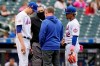 New York Mets starting pitcher Jacob deGrom, left, reacts before leaving the mound without throwing a pitch during the sixth inning of a baseball game against the Arizona Diamondbacks, Sunday, May 9, 2021, in New York. Home plate umpire Manny Gonzalez, second from left, the Mets trainer, second from right, and Mets shortstop Francisco Lindor (12) look on. (AP Photo/Kathy Willens)