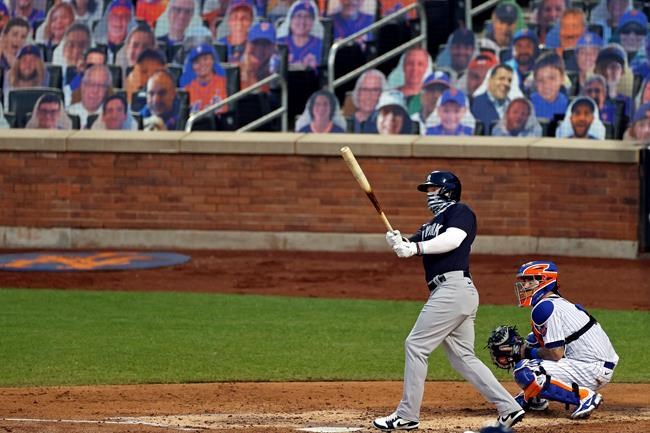 New York Yankees' Clint Frazier, left, watches his two-run home run against the New York Mets during the fourth inning of a baseball spring training game Saturday, July 18, 2020, in New York. (AP Photo/Adam Hunger)