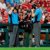 FILE - In this Thursday, June 20, 2019 file photo, Umpires use headsets during a video review of a call during the seventh inning of a baseball game between the St. Louis Cardinals and the Miami Marlins in St. Louis. Taking a chance to review instant replay, Major League Baseball doubled the isolated cameras available for video reviews to 24 this year. (AP Photo/L.G. Patterson, File)