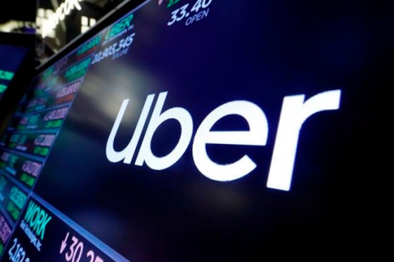 FILE - In this Aug. 16, 2019 file photo, the logo for Uber appears above a trading post on the floor of the New York Stock Exchange. Uber has cut 3,000 jobs from its workforce, its second major wave of layoffs in two weeks as the coronavirus slashed demand for rides. (AP Photo/Richard Drew, file)