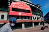 FILE - In this April 16, 2020 file photo, Wrigley Field's marquee displays Lakeview Pantry volunteer information in Chicago. The Chicago Cubs are instituting pay cuts because of the coronavirus crisis, but there will be no furloughs through the end of June. A person with direct knowledge of the situation says the pay cuts were based on compensation. President of baseball operations Theo Epstein and president of business operations Crane Kenney took the highest reductions. The person, who spoke to The Associated Press on Thursday, May 21, 2020 on condition of anonymity because of the sensitivity of the situation, says 80% of associates are taking a pay cut of 20% or less. (AP Photo/Nam Y. Huh, File)