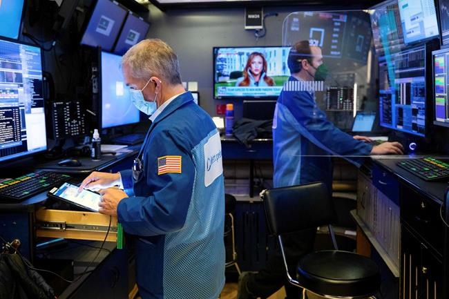 In this photo provided by the New York Stock Exchange, trader Timothy Nick, left, and a colleague work in a booth on the trading floor, Tuesday, Jan. 19. 2021. Stocks are ticking higher on Wall Street Tuesday, recovering some of last week's losses to pull closer to their record highs. (Colin Ziemer/New York Stock Exchange via AP)