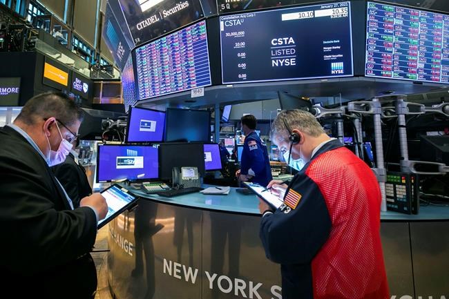 In this photo provided by the New York Stock Exchange, traders Michael Capolino, left, and John Panin, right, work on the floor, Wednesday, Jan. 27, 2021. Stocks were broadly lower in afternoon trading Wednesday, as investors focus on the outlook for the economy and corporate profits amid a still-raging coronavirus pandemic. (Courtney Crow/New York Stock Exchange via AP)