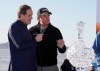 FILE - In this Monday, Feb. 11, 2019, file photo, while being interviewed by broadcaster Jim Nantz, left, Phil Mickelson holds up a silver dollar that belonged to his grandfather during an awards ceremony on the 18th green of the Pebble Beach Golf Links after winning the AT&T Pebble Beach Pro-Am golf tournament, in Pebble Beach, Calif. Nantz has worked the Final Four and Masters for the last 34 years and is missing them in 2020 because of the new coronavirus pandemic. (AP Photo/Eric Risberg, File)