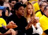 FILE - In this April 28, 2018, file photo, Jay-Z and Beyonce watch Game 1 of an NBA basketball second-round playoff series between the Golden State Warriors and the New Orleans Pelicans in Oakland, Calif. Several top record labels organized Black Out Tuesday on June 2, 2020 as riots erupted around the world sparked by Floyd’s death as well as the killings of Ahmaud Arbery and Breonna Taylor. Musicians including Rihanna, Beyoncé, Taylor Swift, Lil Nas X, Demi Lovato, Post Malone and Harry Styles have spoken out following Floyd’s death and the worldwide riots. (AP Photo/Marcio Jose Sanchez, File)