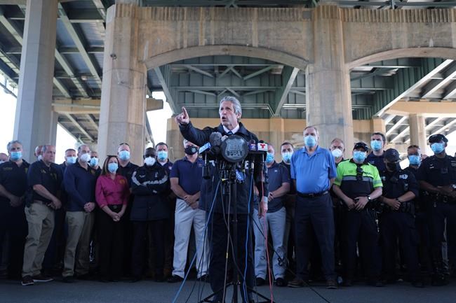 Surrounded by law enforcement and supporters, New York City PBA President Pat Lynch, center, speaks during a news conference in New York, Tuesday, June 9, 2020. A New York City police officer who was caught on video violently shoving a woman to the ground during a protest over the death of George Floyd was charged Tuesday with assault and other counts, prosecutors announced. Lynch said the mayor and police leaders were