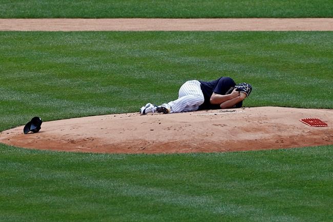New York Yankees pitcher Masahiro Tanaka lies on the field after being hit by a ball off the bat of Yankees Giancarlo Stanton during a baseball a workout at Yankee Stadium in New York, Saturday, July 4, 2020. (AP Photo/Adam Hunger)