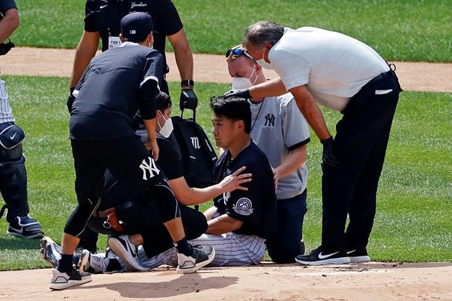 New York Yankees pitcher Masahiro Tanaka is tended to by team medical personnel after being hit by a ball off the bat of Yankees Giancarlo Stanton during a baseball a workout at Yankee Stadium in New York, Saturday, July 4, 2020. (AP Photo/Adam Hunger)