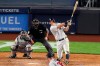 New York Yankees DJ LeMahieu, right, hits an RBI single during the fifth inning of a baseball game against the Atlanta Braves, Wednesday, Aug. 12, 2020, in New York. Braves catcher Travis d'Arnaud, left, and home plate umpire Todd Ticheonor watch. Braves pitcher Josh Tomlin is on the mound (AP Photo/Kathy Willens)
