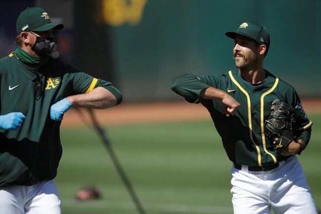 Oakland Athletics' Daniel Mengden, right, bumps elbows with pitching coach Scott Emerson during a baseball practice on Thursday, July 9, 2020, in Oakland, Calif. (AP Photo/Ben Margot)