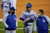 Los Angeles Dodgers' Cody Bellinger, center, walks off the field as he leaves the game with manager Dave Roberts, left, and a trainer during the ninth inning of a baseball game against the Oakland Athletics in Oakland, Calif., Monday, April 5, 2021. (AP Photo/Jeff Chiu)