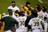 Oakland Athletics players celebrate after Matt Olson, center left, hit a grand slam home run against the Los Angeles Angels in the tenth inning a baseball game in Oakland, Calif., Friday, July 24, 2020. (AP Photo/Jeff Chiu)