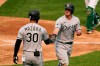 Chicago White Sox's James McCann, right, is congratulated by Nomar Mazara after scoring against the Oakland Athletics during the third inning in Game 3 of an American League wild-card baseball series Thursday, Oct. 1, 2020, in Oakland, Calif. (AP Photo/Eric Risberg)