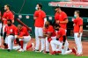 Cincinnati Reds' Phillip Ervin, left, Joey Votto, left middle, Amir Garrett, middle, and Alex Blandino, right, kneel during the national anthem prior to an exhibition baseball game against the Detroit Tigers at Great American Ballpark in Cincinnati, Tuesday, July 21, 2020. (AP Photo/Aaron Doster)