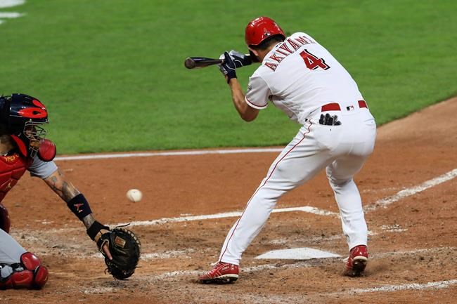 St. Louis Cardinals' Yadier Molina, left, plays the ball as Cincinnati Reds' Shogo Akiyama, right, reacts to being hit by a pitch in the fifth inning during a baseball game at Cincinnati, Wednesday, Sep. 2, 2020. (AP Photo/Aaron Doster)