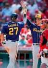 Milwaukee Brewers' Willy Adames (27) celebrates with Christian Yelich after hitting a home run during the ninth inning of the team's baseball game against the Cincinnati Reds in Cincinnati, Sunday, July 18, 2021. (AP Photo/Bryan Woolston)