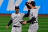 New York Yankees' Aaron Hicks, left, and Aaron Judge celebrate after the Yankees defeated the Cleveland Indians 10-9 in Game 2 of an American League wild-card baseball series, early Thursday, Oct. 1, 2020, in Cleveland. (AP Photo/David Dermer)