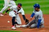 Cleveland Indians' Cesar Hernandez, left, waits for the ball as Kansas City Royals' Adalberto Mondesi slides safely into second base on a steal in the fifth inning of a baseball game, Monday, Sept. 7, 2020, in Cleveland. (AP Photo/Tony Dejak)
