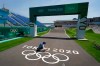 A worker paints Olympic rings at the finish line of the BMX racing track as preparations continue for the 2020 Summer Olympics, Tuesday, July 20, 2021, at the Ariake Urban Sports Park in Tokyo. (AP Photo/Charlie Riedel)