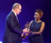 FILE - In this Friday, Dec. 2, 2016 file photo Prince Albert II of Monaco, left, presents Kenyan distance runner Tegla Loroupe with the 2016 President Award at the 2016 World Athletics Gala Awards in Monaco. Laroupe, currently the chief of mission for the IOC's Refugee Olympic Team, has tested positive for COVID-19, two people with knowledge of her condition have told The Associated Press. (AP Photo/Claude Paris)