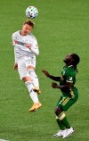Los Angeles FC midfielder Bryce Duke, left, heads the ball away from Portland Timbers forward Yimmi Chara during the first half of an MLS soccer match in Portland, Ore., Sunday, Oct. 18, 2020. (AP Photo/Steve Dykes)