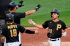 Pittsburgh Pirates' Adam Frazier (26) is welcomed by John Ryan Murphy (18) and Jose Osuna, left rear, after they scored on a single by Pittsburgh Pirates' Ke'Bryan Hayes off St. Louis Cardinals starting pitcher Carlos Martinez, and an error by right fielder Tommy Edman, during the fourth inning of the first baseball game of a doubleheader in Pittsburgh, Friday, Sept. 18, 2020. (AP Photo/Gene J. Puskar)