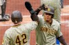 San Diego Padres' Manny Machado, right, is greeted by a teammate after hitting a two-run home run against the Pittsburgh Pirates during the first inning of a baseball game, Thursday, April 15, 2021, in Pittsburgh. (AP Photo/Keith Srakocic)