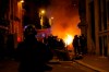 French police officers watch a car burning near the Champs-Elysee avenue following incidents after the Champions League soccer final match between PSG and Bayern Munich which is played in Lisbon, Portugal, Sunday Aug. 23, 2020 in Paris. Bayern Munich won 1-0. (AP Photo/Michel Euler)