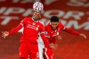 Liverpool's Georginio Wijnaldum heads the ball as he jumps with teammate Liverpool's Joe Gomez during the Champions League Group D soccer match between Liverpool and FC Midtjylland at Anfield stadium, in Liverpool, England, Tuesday, Oct. 27, 2020. (Phil Noble/Pool via AP)