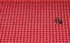 People sit surrounded by empty seats as they wait for the start of the English Premier League soccer match between Liverpool and Bournemouth at Anfield stadium in Liverpool, England, Saturday, March 7, 2020. (AP Photo/Jon Super)